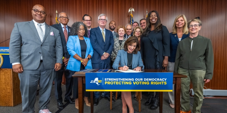 Senator Gianaris with other legislators as Governor Hochul signs the Early Vote by Mail bill