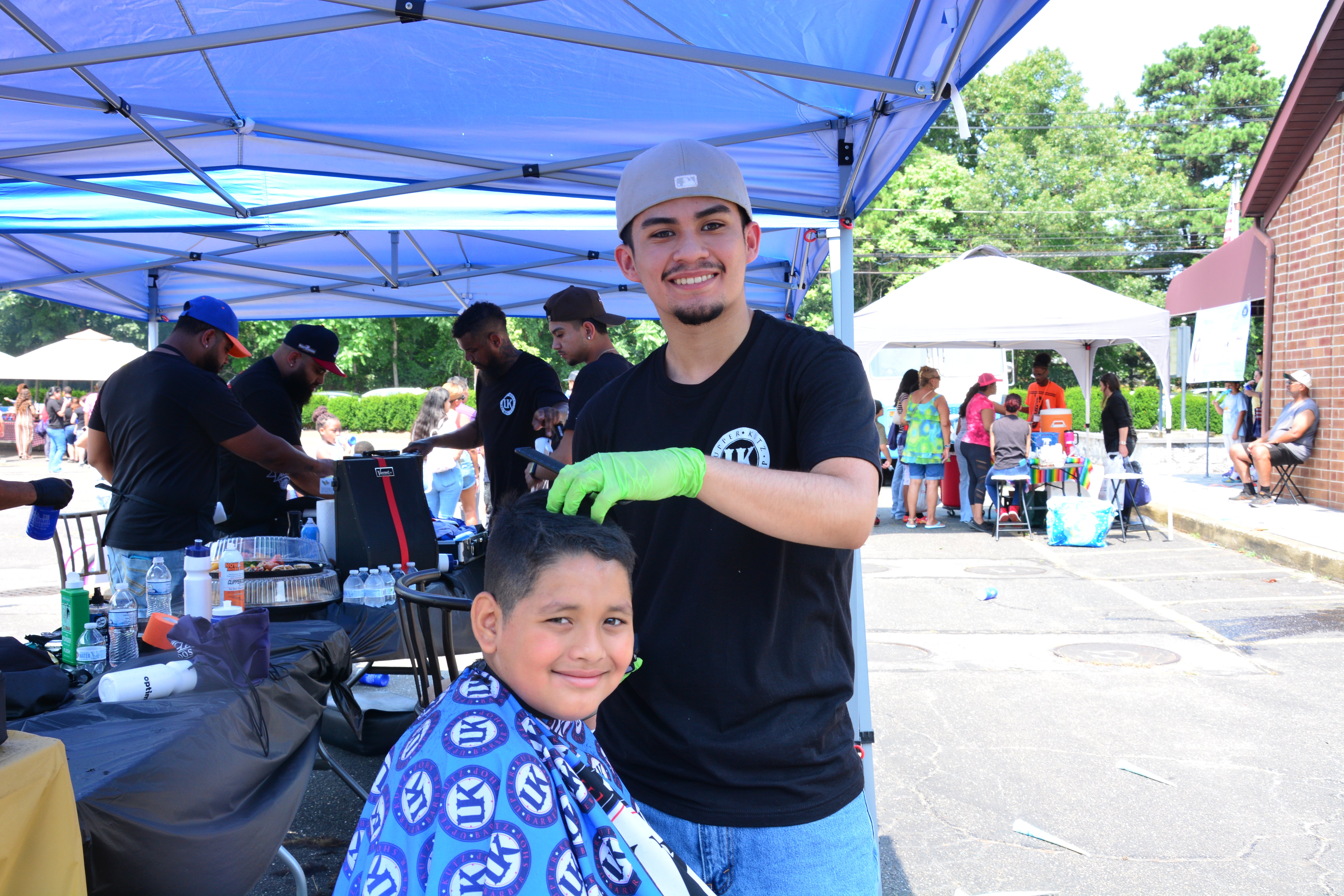 A child gets a haircut during a school supply distribution event held in Brentwood on Aug. 16, 2025.