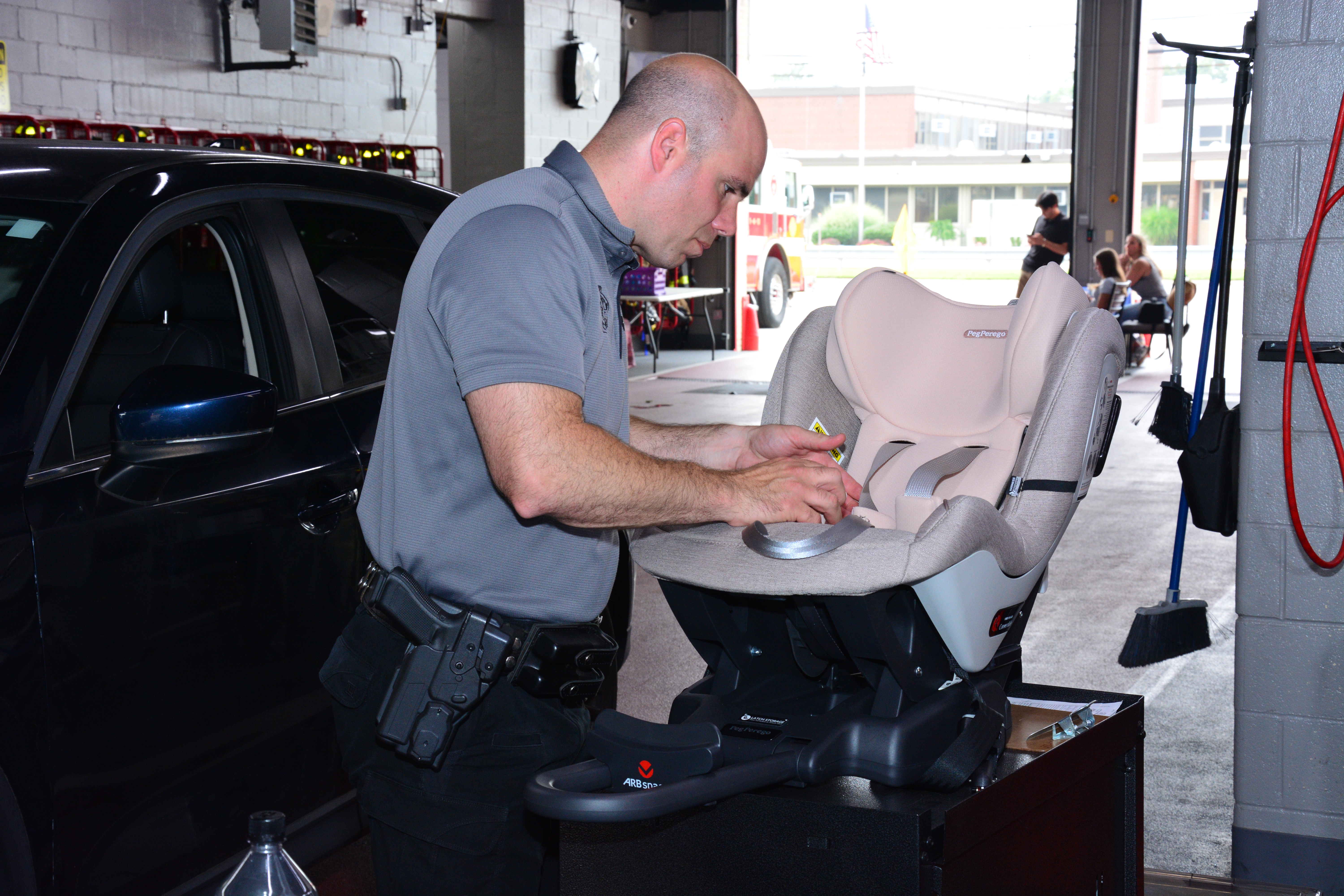 Durante el evento organizado por la senadora estatal Martínez el pasado 26 de julio, un policía estatal de Nueva York inspecciona un asiento infantil para asegurarse que este luego vaya instalado correctamente en el vehículo.