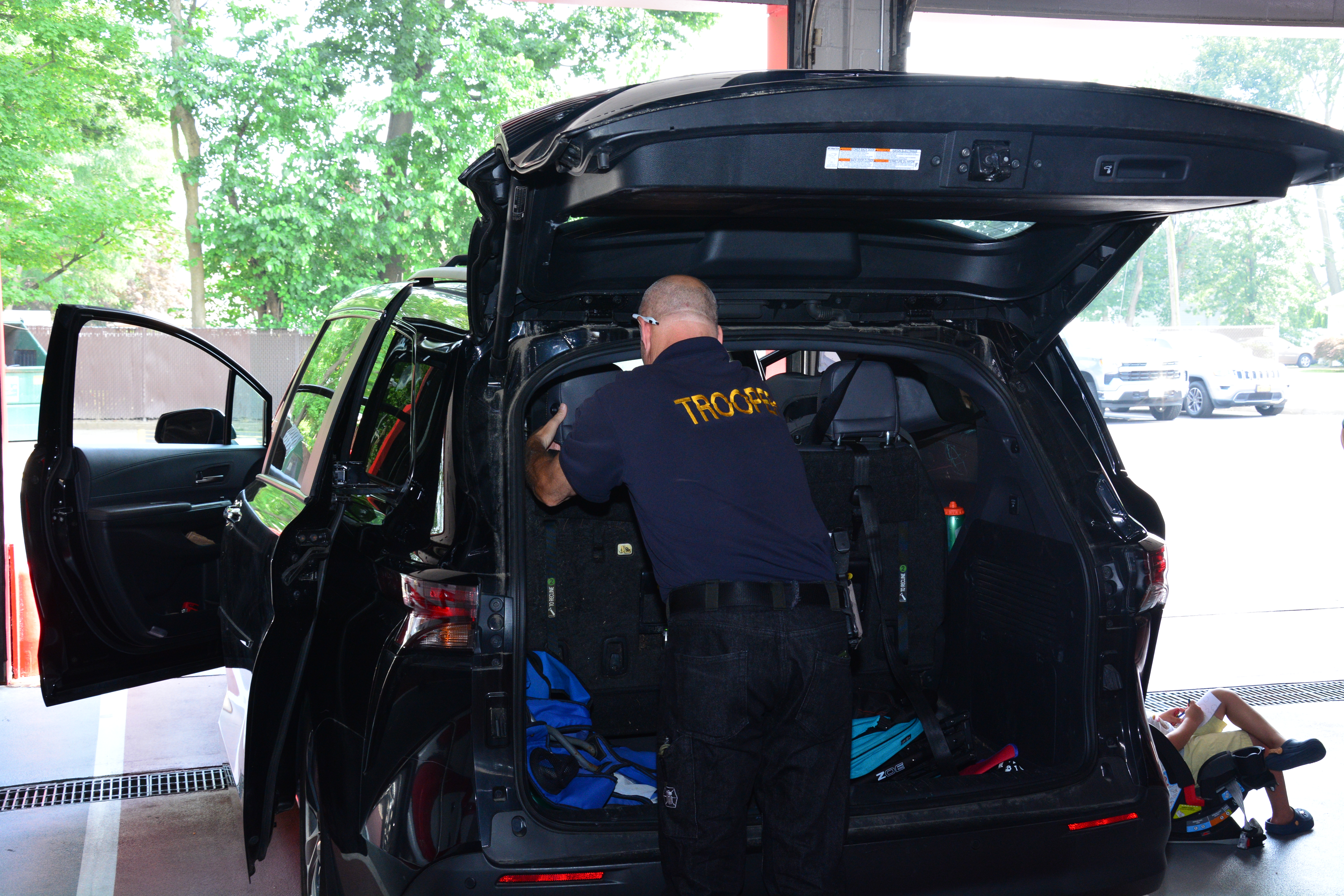 Durante el evento organizado por la senadora estatal Martínez el pasado 26 de julio, un policía estatal de Nueva York inspecciona un asiento infantil para asegurarse que este luego vaya instalado correctamente en el vehículo.