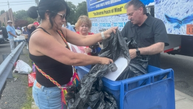 Senator Addabbo helps constituents empty their bags of paper to be shredded.