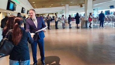 Senator Addabbo greets a job seeker while a long line of other attendees waits to explore the employment opportunities at the event.