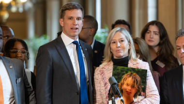 Senator Erik Bottcher and Diana Cochran, Francesco's mother, stand together at a press conference speaking to the media.