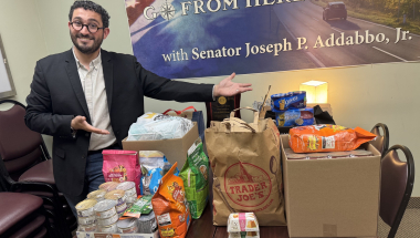 Senator Addabbo's Chief of Staff, Raimondo Graziano, displays the donations that were collected as a result of the pet food drive.