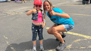 NYS Senator Monica R. Martinez and a child who attended the 2025 Backpack and School Supply Distribution event give the thumbs up.