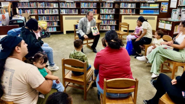 Senator Addabbo reads a book to the children during a storytime session at the library.