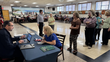 Alfred Gryszkiewicz from the Comptroller's Office helps a long line of attendees at the Peter Cardella Senior Center search for unclaimed funds.