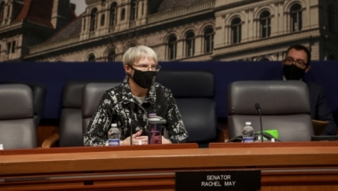 Senator May seated at hearing