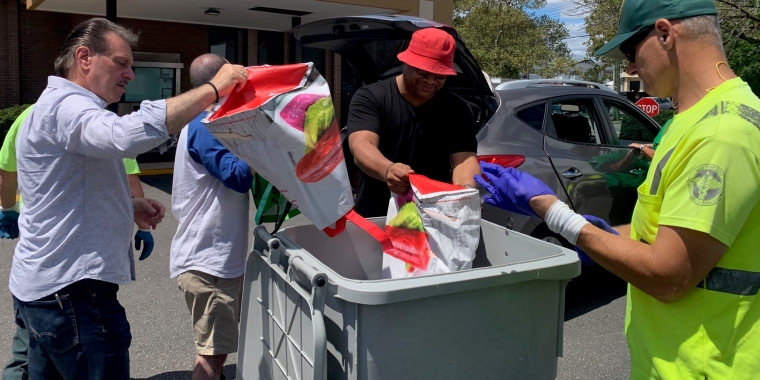 Senator Addabbo and staffers from the Department of Sanitation help constituents empty paper into bins ready for disposal