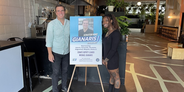 Senator Gianaris and a constituent stand with a sign promoting his G-mobile event
