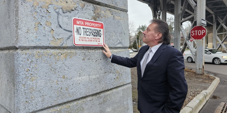 Senator Addabbo views one of the new No Trespassing signs at the Babbage and Bessemer trestle to prohibit illegal parking in the bays.