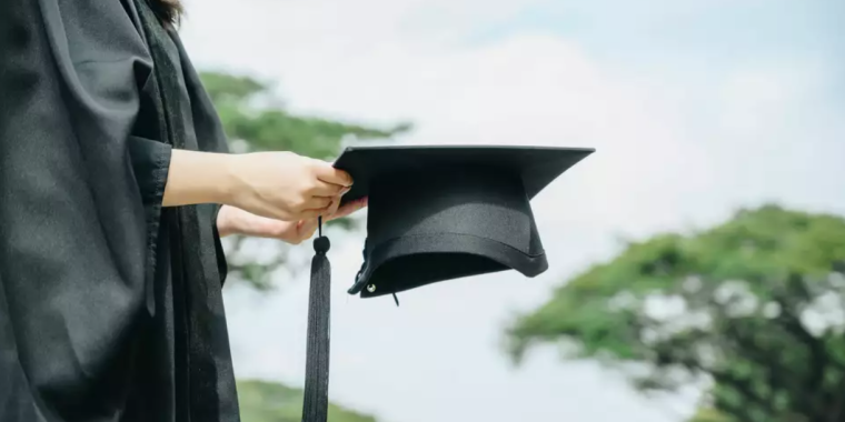 A generic image of a college graduate holding their cap.