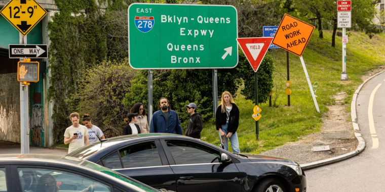 Pedestrians waiting to cross an unsafe street at an entrance to the Brooklyn-Queens Expressway