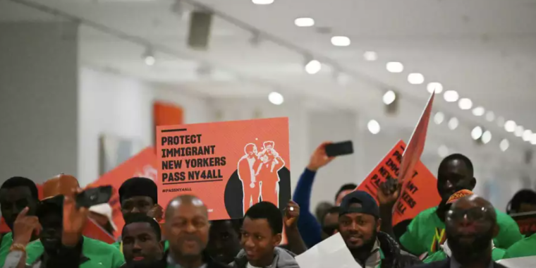 Demonstrators march through Empire State Plaza Concourse in support of the New York for All Act.