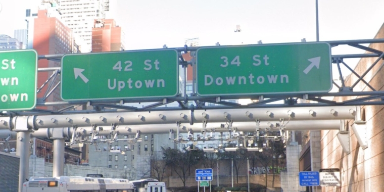 Highway signs for Uptown and Downtown exits from Lincoln Tunnel.