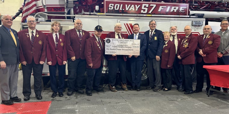 Senator Ryan and Volunteer Firefighters in front of a fire truck to present a $120,000 check