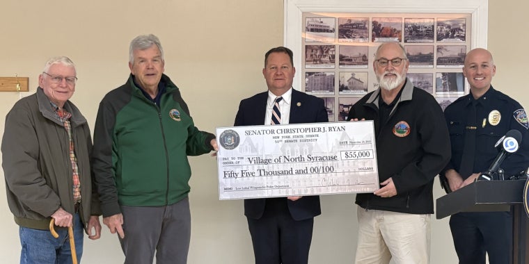 Group of people standing together with a check presentation for $55,000 to the Village of North Syracuse Police Department