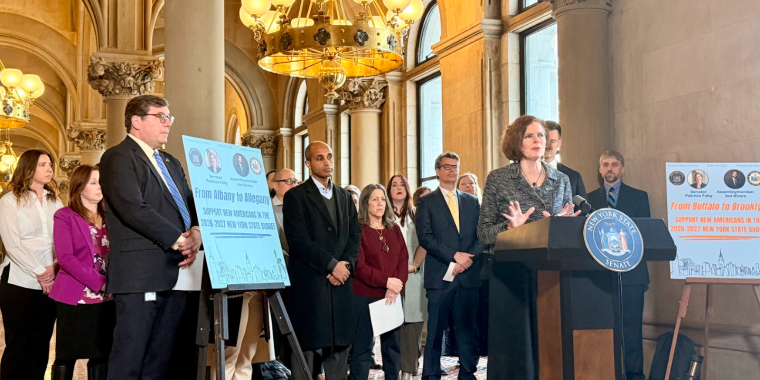 Senator Fahy standing with refugee service directors and advocates