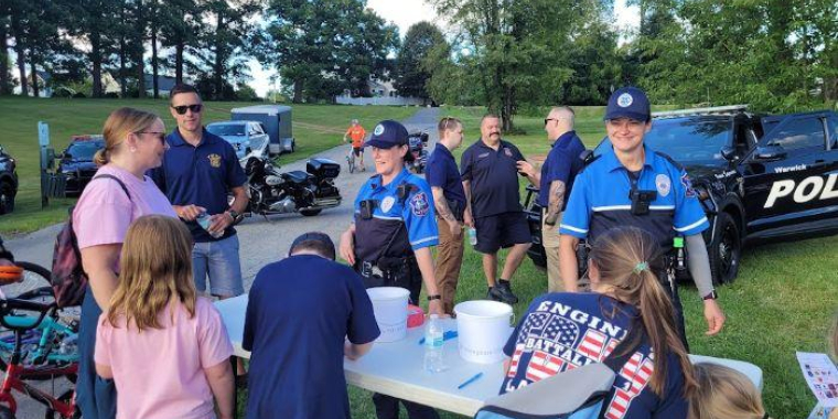 Officers from the Warwick Police Department speak with residents at the National Night Out event in 2023.
