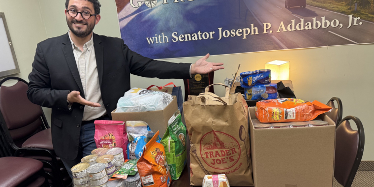 Senator Addabbo's Chief of Staff, Raimondo Graziano, displays the donations that were collected as a result of the pet food drive.
