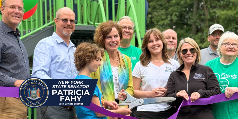 Senator Fahy, Town Supervisor David VanLuven, and residents cut ribbon on the new playground in background