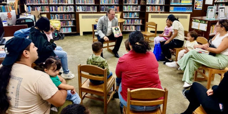 Senator Addabbo reads a book to the children during a storytime session at the library.
