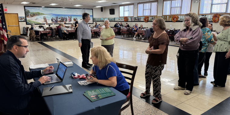 Alfred Gryszkiewicz from the Comptroller's Office helps a long line of attendees at the Peter Cardella Senior Center search for unclaimed funds.