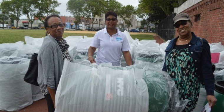 Karen Ellis, center, Borough Coordinator for NYC DEP assists residents, Veronica Smart and Floretta Sage of Springfield Gardens, carry away their rain barrel.