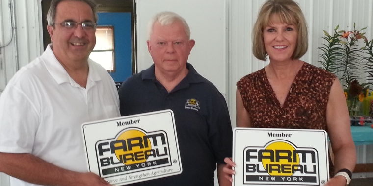 Cattaraugus County Farm Bureau President Chuck Couture presents Senator Young and Assemblyman Giglio with placards honoring their dedication to agriculture and local farmers.