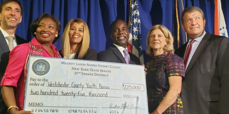 NYS Senate Majority Leader Andrea Stewart-Cousins with State Senator Shelley Mayer presenting $225,000 check to County Executive George Latimer and Westchester County Youth Bureau Executive Director Dr. DaMia Harris-Madden with New Rochelle Mayor Noam Bramson and Mount Vernon Mayor Andre Wallace in attendance. 