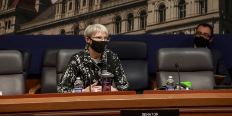 Senator May seated at hearing