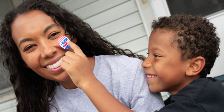 Child places early voting sticker 