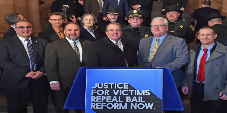local participants at Tuesday’s "Repeal Bail Reform" rally, front row, l. to r.: Assemblyman Joseph Giglio, Assemblyman Phil Palmesano, Steuben County District Attorney Brooks Baker, Senator Tom O’Mara, Hornell Mayor John Buckley. Back row, l. to r.: Assemblyman Chris Friend, Assemblywoman Marjorie Byrnes, Steuben County Undersheriff John McNelis, Bath Police Chief Chad Mullen, Steuben County Sheriff James Allard. 
