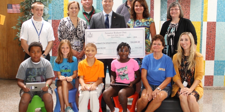 Pictured at Roy B. Kelley Elementary School from left to right: Front Row: Roy B. Kelley Fourth Grade Students Jamar Swanson, Lianna Dever, Amire Tate, and Lashawnda Harper; Lockport City School District Motor Equipment Operator Linda Cline; and Library Media Specialist at Roy B. Kelley & Anna Merritt elementary schools Rachel O’Sheeham. Middle Row: Roy B. Kelley Fourth Grade Teacher Tom Sarratori; Asst. Supt. of Finance for Lockport City School District Deborah A. Coder; Senator Rob Ortt; Lockport City School District Superintendent Michelle T. Bradley; and Lockport Public Library Children’s Librarian Linda Deeks. Back Row: Aramark Food Service Dir. for Lockport City School District Tom Heagerty, and Lockport City School District Maintenance Supervisor Kevin Guay.