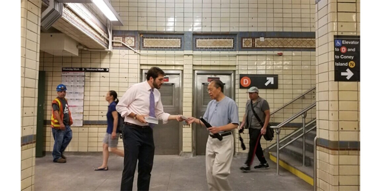 State Sen. Andrew Gounardes hands one of his subway surveys to a rider at the New Utrecht Avenue/62nd Street D/N train station. Photo by: Despina Costalas