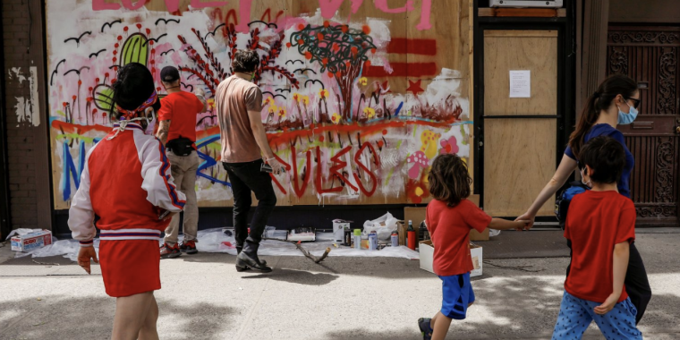 Artists paint a mural on a boarded-up storefront as part of neighborhood project in the Bowery neighborhood of Manhattan in New York City, New York, U.S., June 17, 2020. Picture taken June 17, 2020. (REUTERS/Brendan McDermid)