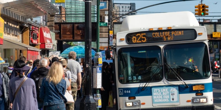 People wait to board an MTA bus in Flushing, Queens on May 17, 2021. (Shutterstock)