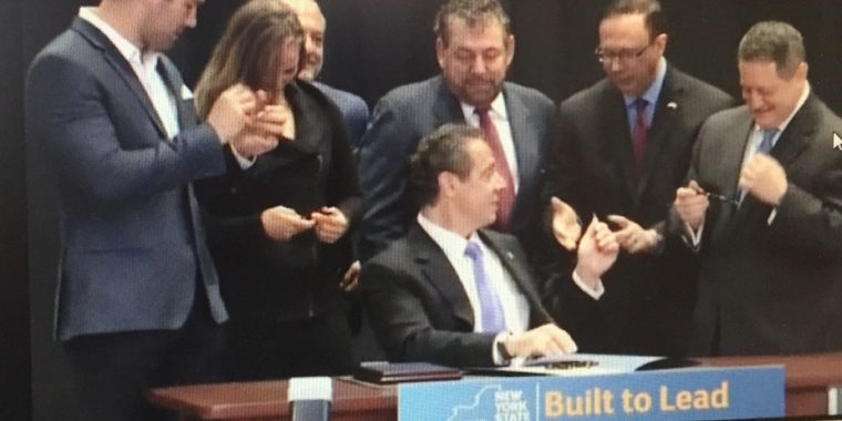 Governor Cuomo hands Senator Griffo one of the pens he used to sign the Senator's legislation that legalizes professional mixed martial arts in New York State.