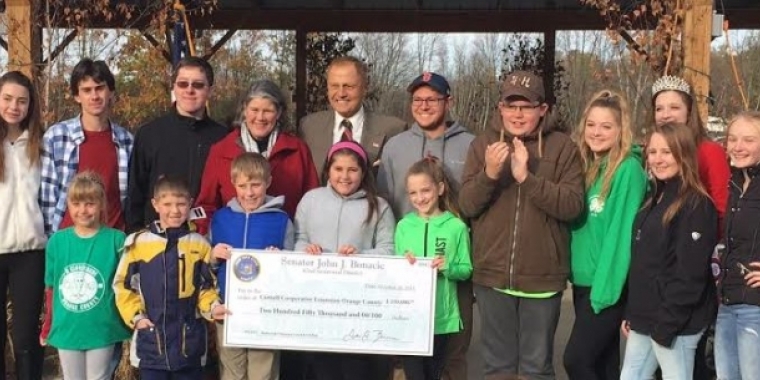Senator Bonacic presents a $250,000 check to Cornell Cooperative Extension of Orange County. Pictured to the left of Senator Bonacic is Lucy Joyce, Executive Director of the Cornell Cooperative Extension of Orange County. He is also pictured with Orange County 4-H students.