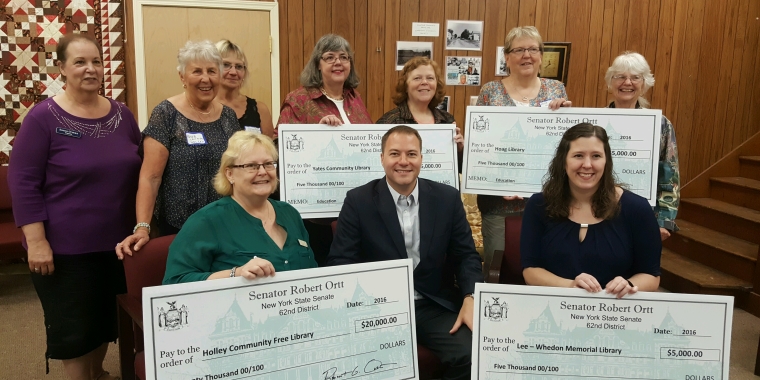 Pictured at the Holley library from left to right: Front Row: Community Free Library Dir. Sandra Shaw; Senator Rob Ortt; and Lee-Whedon Memorial Library Board Member Kristine Mostyn. Back Row: Community Free Library Board Member Sue Orman; Community Free Library Board Member Barbara Lehning; Community Free Library Supporter Sue Persia; Yates Community Library Dir. Emily Cebula; Yates Community Library Board Member Kathleen Sillick; Hoag Library Dir. Betty Sue Miller; and Community Free Library Board President Barbara Kerns.