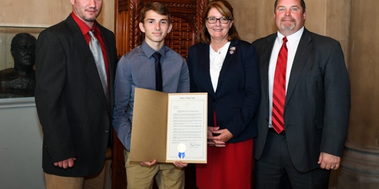 From left, Palmyra-Macedon Red Raiders wrestling coach John Burgess, NYSPHSAA Division II 99-pound state champion Jace Schafer, Senator Pam Helming, and Palmyra-Macedon Central School District Athletic Director Tom Schmandt.