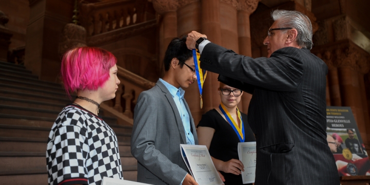 Pictured L-R: Ava Horton, Meka Boncie-Machin and Emily St. John receiving the NYS Liberty Medal from Senator Jim Tedisco.