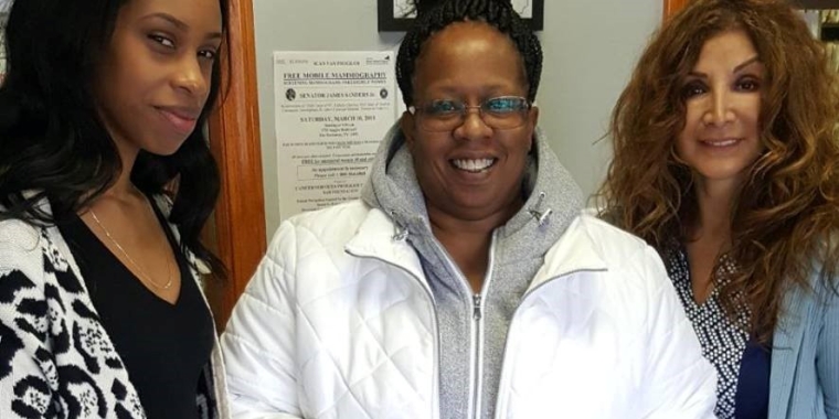 Elisciea Anderson, a staffer at South Island Medical Associates, left, and Gina Vasquez, Founder and President of Flowers of Hope, present a gift bag to one of the mammogram patients.