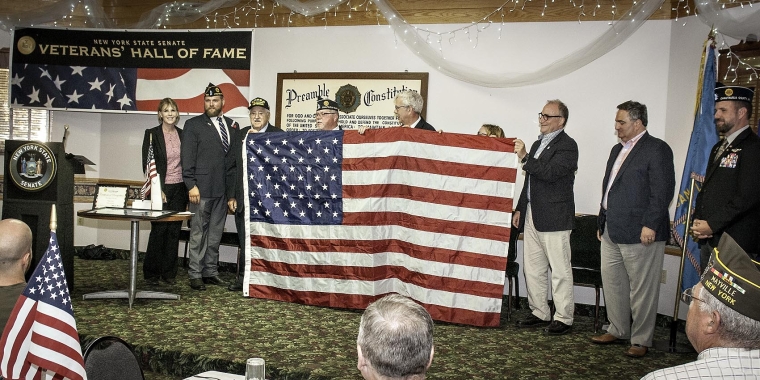 From left to right: Senator Young, Brandan Yeskey, Commander, Frewsburg American Legion; honoree Peter Carlo; Calvin Fain, Chaplain; Assemblyman Andy Goodell; Katrina Fuller, representing Congressman Tom Reed (partially obscured); Vince DeJoy, Director of Development for the City of Jamestown; George Borrello, Chautauqua County Executive; Greg Carlson, Director, Chautauqua County Veterans’ Service Agency.