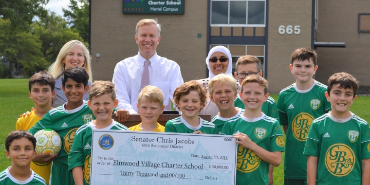 L-R - Delaware Soccer Club President Ellen Shanahan Becker, State Senator Chris Jacobs, Director of the Elmwood Village Charter School's Hertel Avenue Location Kathy Jamil, and young athletes from the Delaware Soccer Club.