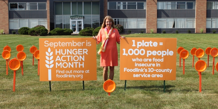Senator Pam Helming stands among a Hunger Action Month display of orange plates at the Foodlink regional food hub in Rochester that depicts the 156,000 people within its 10-county coverage area who are considered food insecure following her tour on Friday, Sept. 22.