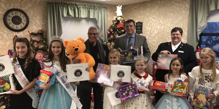 Tedisco donating a teddy bear and presenting a NYS Senate citation to Salvation Army Captain Wendy Senior. The second picture is of Tedisco with Wendy Senior, Leonard Hersh, Administrator for the Fulton Center, and several Fulton and Fonda Fair Princesses who helped collect toys for the Salvation Army's Toy Drive. Tedisco presented Senate citations to the princesses.