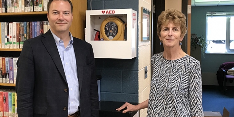 Senator Rob Ortt and Lee-Whedon Memorial Library Director Catherine Cooper stand in front of the newly installed AED. Senator Ortt funded the life-saving device, a computer coding class and music program by securing $5,000 for the Orleans County library.