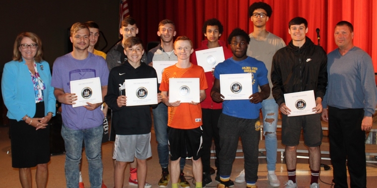 Senator Pam Helming with Head Coach Dean Schott II and members of the Lyons Lions boys varsity basketball team that won the Section V, Class C2 championship during the winter season.