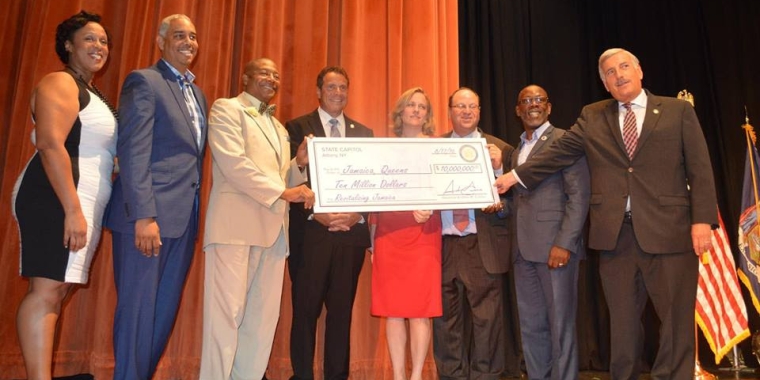 Senator Sanders (third from left) accompanies Governor Cuomo as he presents a check for $10M for the revitalization of Jamaica. They are joined by Assembly Member Alicia Hyndman, City Council Member Rubin Wills, Queens Borough President Melinda Katz, City Council Member Barry Grodenchik, City Council Member I. Daneek Miller and Assembly Member David Weprin.